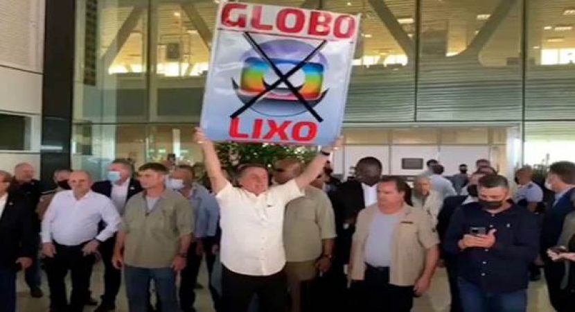 Bolsonaro levanta placa escrito Globo Lixo
